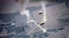 Foto dari tangkapan layar oleh Angkatan Udara AS tampak suar-suar yang dipasang di parasut melayang di udara. Suar-suar itu menurut AU AS dilepaskan oleh jet Rusia, SU-35, di atas wilayah udara Suriah, Rabu, 5 Juli 2023. (Foto: U.S. Air Force via AP)