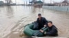 Tim SAR mengarungi jalan yang banjir dalam perjalanan mengevakuasi warga di wilayah Orenburg, tenggara ujung selatan Pegunungan Ural, Rusia, Sabtu, 6 April 2024. (Foto: Russian Emergencies Ministry/AFP)