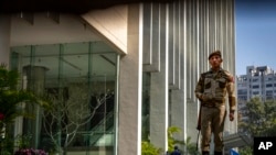 Një person i armatosur qëndron roje tek hyrja e një ndërtese ku ndodhen zyret e BBC-së në Nju Delhi, Indi, 15 Shkurt 2023.