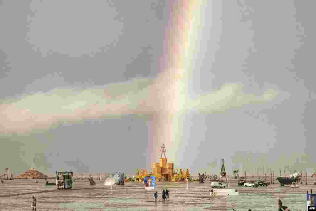 This handout image provided courtesy of Josh Lease on Sept. 3, 2023 shows a rainbow over flooding on a desert plain on Sept. 1, 2023, after heavy rains at the annual Burning Man festival site in Nevada's Black Rock desert.