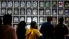 FILE - People pay their respects in a marquee filled with photos of victims as they attend a vigil in Seoul on Oct. 29, 2023, to mark the first anniversary of the crowd crush that killed 159 people in Seoul's popular Itaewon nightlife area a year ago. 