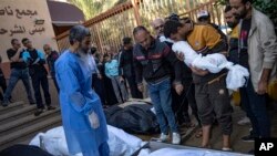 গাজা ভূখণ্ডে খান ইউনিসের এক হাসপাতালে ইসরাইলি বোমাবর্ষণে নিহত আত্মীয়দের জন্য শোক করছেন ফিলিস্তিনিরা (১৮ নভেম্বর, ২০২৩)