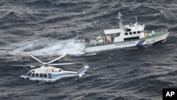Helikopter penjaga pantai dan kapal patroli Jepang melakukan operasi pencarian dan penyelamatan di perairan tempat pesawat militer AS Osprey jatuh di lepas pantai Pulau Yakushima, prefektur Kagoshima, Jepang selatan, 30 November 2023. (Foto: Kyodo via AP)