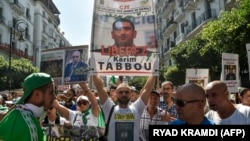Des manifestants demandent la libération de Karim Tabbou à Alger, le 27 septembre 2019. (Photo by RYAD KRAMDI / AFP)