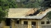 ফাইল – ২০১৭ সালের ১৫ই নভেম্বর ক্যামেরুনের উত্তর-পশ্চিমাঞ্চলের ইংরেজিভাষী অঞ্চলের বাফুতে আগুন লাগার পরে একটি স্কুলের ক্ষতিগ্রস্থ ছাত্রাবাসের বাইরে দাঁড়িয়ে একজন মহিলা 