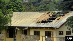 ফাইল – ২০১৭ সালের ১৫ই নভেম্বর ক্যামেরুনের উত্তর-পশ্চিমাঞ্চলের ইংরেজিভাষী অঞ্চলের বাফুতে আগুন লাগার পরে একটি স্কুলের ক্ষতিগ্রস্থ ছাত্রাবাসের বাইরে দাঁড়িয়ে একজন মহিলা 