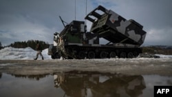 Фінський солдат поруч з реактивною системою залпового вогню M270, якою керують Сили оборони Фінляндії, під час міжнародних військових навчань Cold Response 22, у Сетермуені, на півночі Норвегії, 22 березня 2022 року. (Фото Джонатана НАКСТРАНДА / AFP)