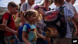 Внутрішньо переміщені особи сідають у потяг, що прямує до Дніпра, на залізничній станції Покровськ, Донецька область, східна Україна, 8 липня 2022 року. (AP Photo/Nariman El-Mofty)