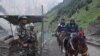 ভারতের পবিত্র অমরনাথ গুহায় যাত্রার সময় তীর্থযাত্রীরা পাহাড়ি পথ অতিক্রম করার সময় ভারতীয় নিরাপত্তা রক্ষীরা নজরদারি করে। 