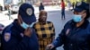 Une femme proteste après avoir été gazée par un membre des services de police sud-africains pour ne pas avoir porté de masque facial à Hillbrow, Johannesburg le 1er mai 2020.