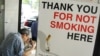 FILE - A man has his lunch behind a poster demarcating a No-Smoking zone in Singapore.