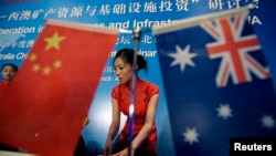 在一场中澳资源与基础设施投资研讨会上，一名服务人员正在整理资料。2009年7月23日