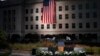 The podium awaits the arrival of President Donald Trump as a U.S. flag is unfurled at the Pentagon on the 16th anniversary of the September 11th attacks, Sept. 11, 2017. 