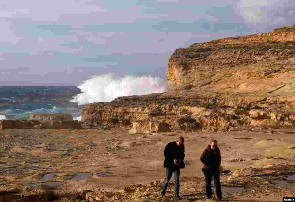Tourists walk away after viewing the site where the natural structure known as the Azure Window collapsed, after the Maltese islands were hit by rough seas and stormy weather, at Dwejra on the island of Gozo, Malta, March 8, 2017.