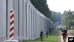 Польський прикордонник патрулює поблизу загорожі на кордоні Польщі з Білоруссю, червень 2022 року AP Photo/Michal Dyjuk