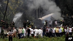 Cuba's President Miguel Diaz-Canel, third from left, walks away from the site where a Boeing 737 plummeted into a yuca field with more than 100 passengers on board, in Havana, May 18, 2018.