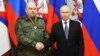 Presiden Rusia Vladimir Putin berjabat tangan dengan wakil komandan operasi militer Rusia di Ukraina Jenderal Sergei Surovikin, saat ia dianugerahi medali "Saint George" di markas besar Distrik Militer Selatan, Rusia, Sabtu, 31 Desember 2022.