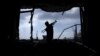 FILE - An Afghan policeman inspects a building used by insurgents after an operation near the Indian consulate in Mazar-i-Sharif, Afghanistan, Jan. 5, 2016. 