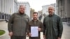 Президент Володимир Зеленський, прем’єр-міністр Денис Шмигаль (праворуч) і голова Верховної Ради України Руслан Стефанчук тримають заявку на «прискорений вступ до НАТО». Фото надано Офісом президента України. 30 вересня 2022 року.