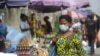 FILE - A woman wearing a face mask to protect against the novel coronavirus walks on a street in Lagos, Nigeria , Dec. 31, 2020. 