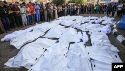 শুহাদা আল-আকসা হাসপাতালে কেন্দ্রীয় গাজা উপত্যকার দেইর বালাহতে ইসরাইলের বোমা হামলায় নিহতদের মৃতদেহ নিয়ে শোক প্রকাশ করার সময় ফিলিস্তিনিরা জড়ো হচ্ছে। ৬ নভেম্বর, ২০২৩।