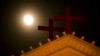 FILE - The moon rises above a pair of crosses on the roof of Holy Trinity Church in Wenzhou in eastern China's Zhejiang Province.