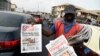 A roadside vendor holds a newspaper announcing the appointment of Ngozi Okonjo-Iweala as WTO Secretary-General in Ibadan, southwest of Nigeria, Feb. 16, 2021. 