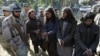 Taliban militants, right, who were arrested by Afghan border police, stand during a presentation of seized weapons and equipment, Jalalabad, Dec. 29, 2015.