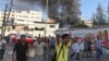 A Palestinian reacts as smokes rises at the scene of what witnesses said was Israeli shelling near a market in Shejaia in the east of Gaza City, July 30, 2014. 