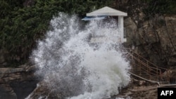 Gelombang yang ditimbulkan oleh Topan Saola pecah di samping menara penjaga pantai di sebuah pantai di Hong Kong pada 1 September 2023. (Foto: AFP)