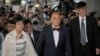 Donald Tsang, center, former leader of Hong Kong and his wife Selina arrive at a magistrates' court in Hong Kong Monday, Oct. 5, 2015.