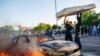 Des manifestants jettent un matelas sur une voiture en feu devant un magasin près du troisième commissariat de police le 28 mai 2020 à Minneapolis, dans le Minnesota, Etats-Unis. (Photo Kerem Yucel / AFP)