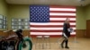 Una mujer, parte del personal de la campaña del candidato presidencial demócrata estadounidense Bernie Sanders, Mueve sillas antes de un evento de campaña.